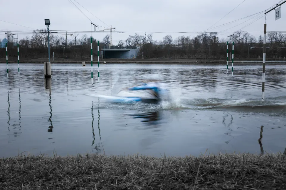 Závodník ve vodním slalomu projíždí peřej